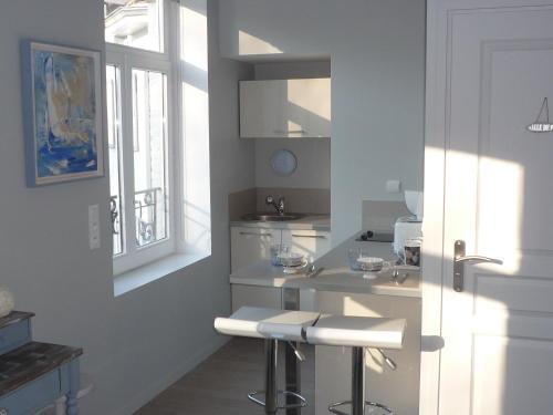 a white kitchen with a sink and a window at La Villa Carat Croix in Croix