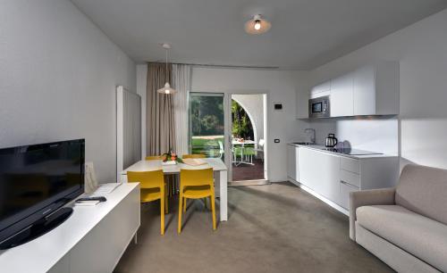 a kitchen and living room with a table and a couch at Du Lac Et Du Parc Grand Resort in Riva del Garda
