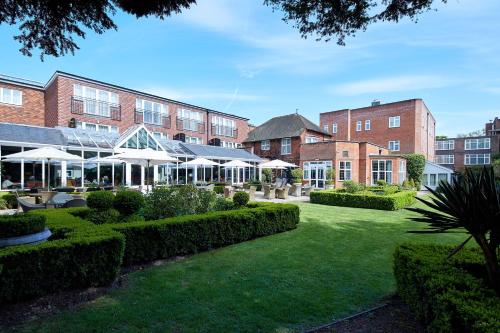 a courtyard of a building with bushes and trees at The Bull in Gerrards Cross