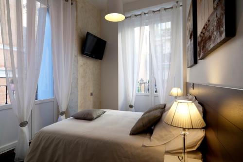 a bedroom with a bed with a lamp and a window at THC Latina Hostel in Madrid