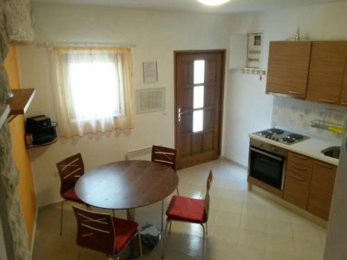 kuchnia z drewnianym stołem i krzesłami oraz stołem i stołem w obiekcie Rogoznica Apartment w Rogoznicy