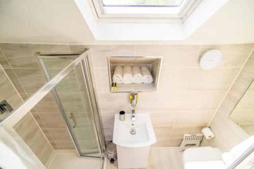 uma casa de banho com um lavatório e um chuveiro em Sea View Holiday Flat - Covehurst Bay em Hastings