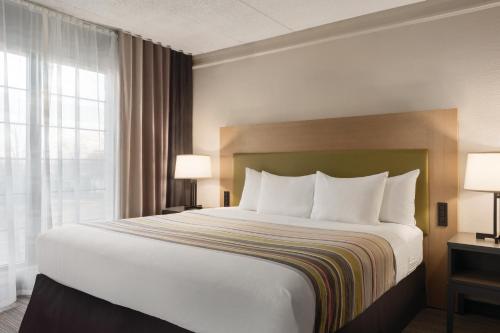 a hotel room with a large bed and a window at Country Inn & Suites by Radisson, Chicago-Hoffman in Hoffman Estates