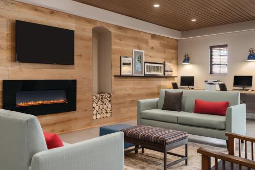 a living room with a fireplace and a tv at Country Inn & Suites by Radisson, Chicago-Hoffman in Hoffman Estates