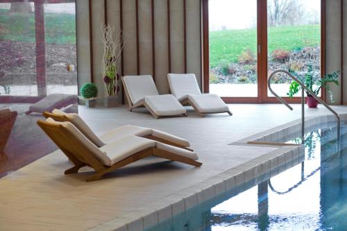 a group of chairs sitting next to a swimming pool at Grund Resort Golf and Ski in Mladé Buky