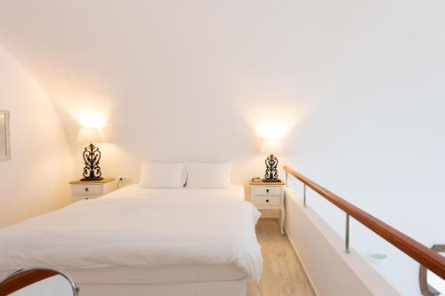 a bedroom with two beds and two lamps at Desiterra Resort & Spa in Fira