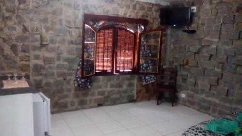 a kitchen with a brick wall and a window at Villaggio D'Amore in Monte Verde