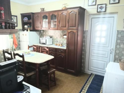 a kitchen with wooden cabinets and a table and a refrigerator at Casa Rafael in Belmonte