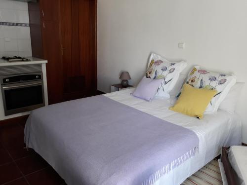 1 dormitorio con 1 cama blanca grande con almohadas coloridas en Casa de Campo Quinta São Jorge, en Reguengos de Monsaraz