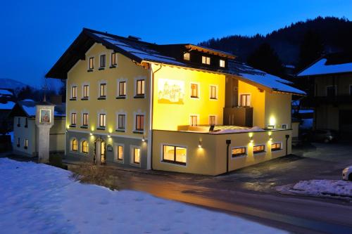 a large yellow building with lights on it at night at Werfenerhof in Werfen