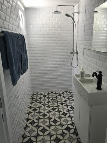 a white bathroom with a black and white tiled floor at Balatonszemes small House in Balatonszemes