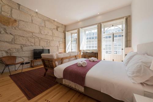 ポルトにあるLovelyStay - Allderman Apartment - Almada 3º Fの石壁のベッドルーム1室(大型ベッド1台付)