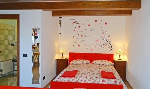 una camera con letto rosso e cuscini rossi di Casa Paola Holiday studio by Gardadomusmea a Tremosine Sul Garda