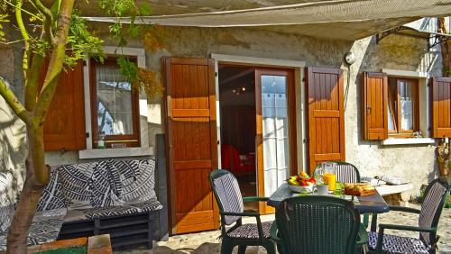 un patio con tavolo e sedie su una casa di Casa Paola Holiday studio by Gardadomusmea a Tremosine Sul Garda