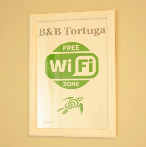 a picture of a free wifi zone sign on a wall at Tortuga in Sassari