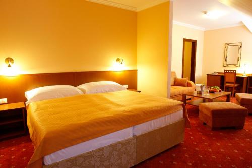 a bedroom with a large bed and a living room at Hotel Majolika in Modra