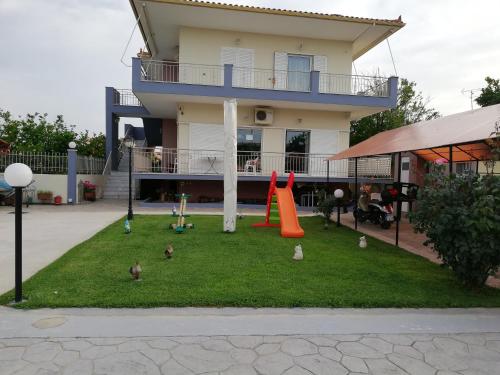 a group of birds sitting on the grass in front of a house at Rea's House Vrachati in Vrahati