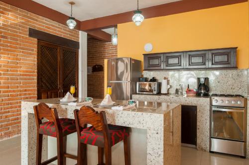 a kitchen with a counter with two bar stools at Vallarta Shores Beach Hotel in Puerto Vallarta