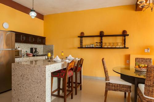 a kitchen with yellow walls and a table with chairs at Vallarta Shores Beach Hotel in Puerto Vallarta