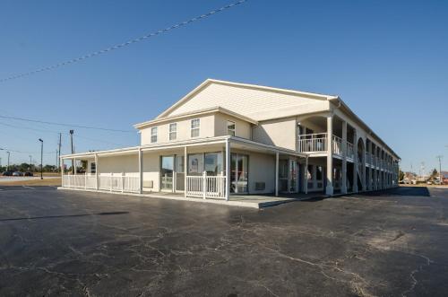 a large white building with a parking lot at Motel 6-Commerce, GA in Commerce