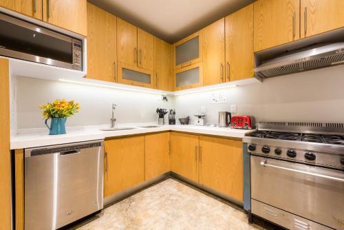 a kitchen with wooden cabinets and stainless steel appliances at La Palomilla Bed & Breakfast in Mexico City