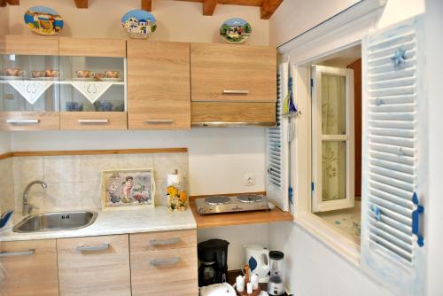 a kitchen with wooden cabinets and a sink at Kassandra House in Hydra