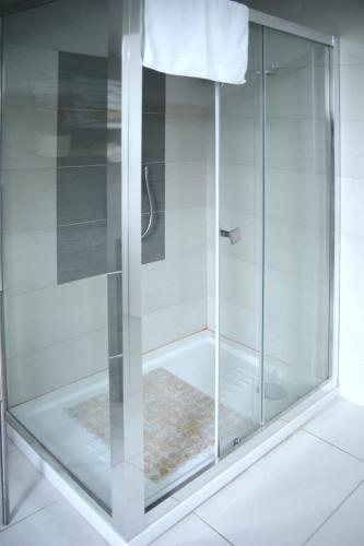 una ducha con puerta de cristal en un baño en B&B Villa Garden, en Bisceglie