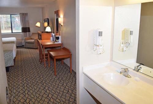 a bathroom with a sink and a living room at Beachfront Hotel Houghton Lake in Houghton Lake