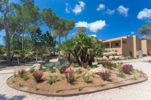 a garden with flowers in front of a building at Ses Eufabietes Apartments & Restaurant in Sant Francesc Xavier