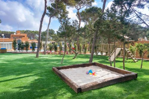 a sandbox in a park with a playground at Ses Eufabietes Apartments & Restaurant in Sant Francesc Xavier