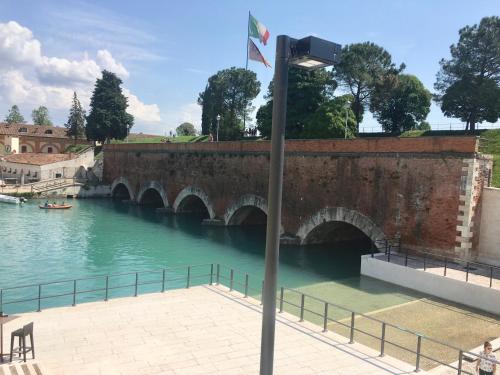 a street light next to a river with a bridge at Ponte dei Voltoni Apartment in Peschiera del Garda