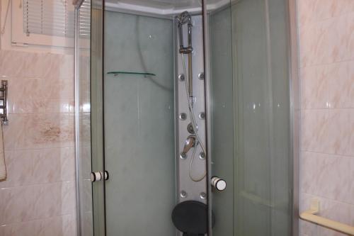 a shower with a glass door in a bathroom at Orwa apartmanok - Cédrus köz in Zalakaros