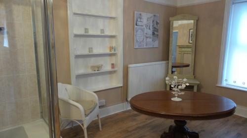a dining room with a table and a shower at Hooray Henrys in Sheringham