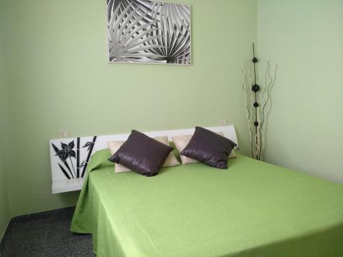 uma cama verde com duas almofadas em cima em Ricky em Arrecife