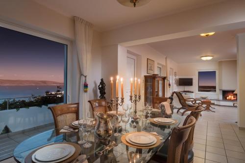 a dining room with a table and chairs with a view at Sounio Villa in Sounio
