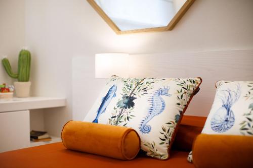 a room with a couch with a pillow and a window at MelRose Sorrento in Sorrento