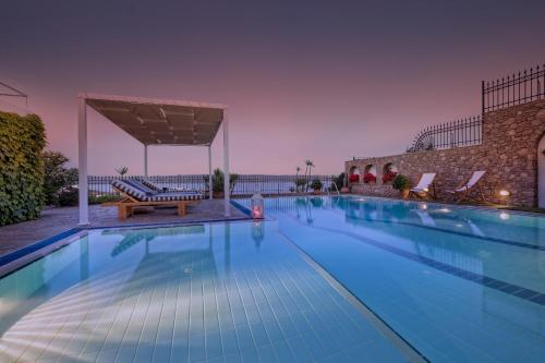 a large swimming pool with a table and a bench at Sounio Villa in Sounio