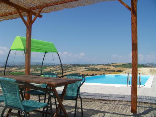 una mesa y sillas en un patio con piscina en casa cologna glamping en Cologna