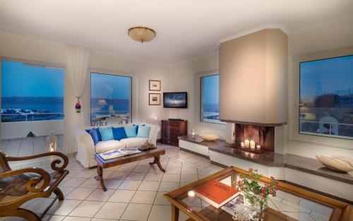 a living room with a couch and a fireplace at Sounio Villa in Sounio