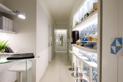 a corridor of a kitchen with white and blue tiles at MelRose Sorrento in Sorrento