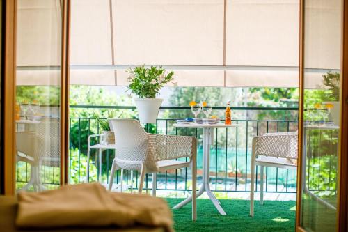 a balcony with chairs and a table with a plant at MelRose Sorrento in Sorrento