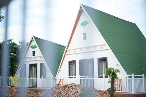 a large white house with a green roof at Carambola Bungalow in Phong Nha