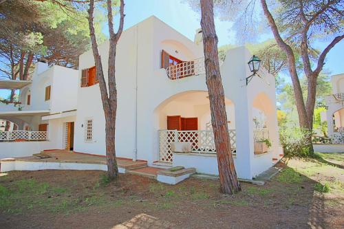 una casa blanca con árboles delante de ella en Ville Campo Verde by TerraSalento, en San Cataldo