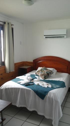 a bedroom with a bed with towels on it at Pousada Tranquila in Morro de São Paulo