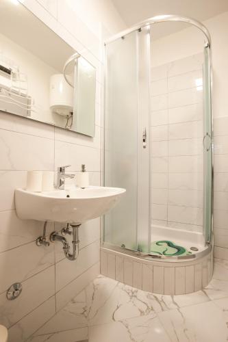a bathroom with a sink and a shower at Apartments Aria in Zadar