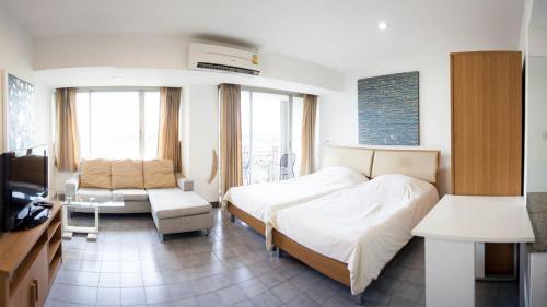 een slaapkamer met een bed, een bank en een tv bij Galare Thong Tower in Chiang Mai