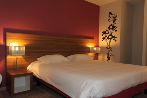 a bedroom with a large white bed and two lamps at ibis Styles Castres in Castres