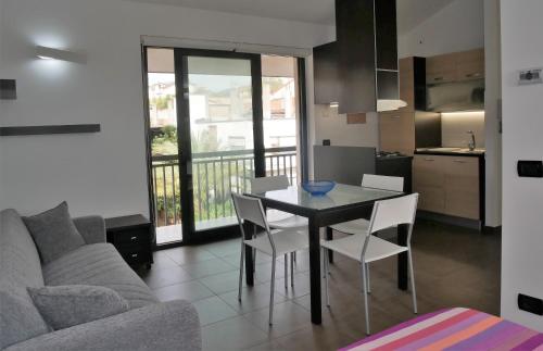 a living room with a table and chairs and a kitchen at Aspromontando in Polistena