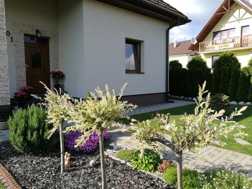 a garden in front of a house with trees at Ubytovanie na súkromí in Veľká Lomnica