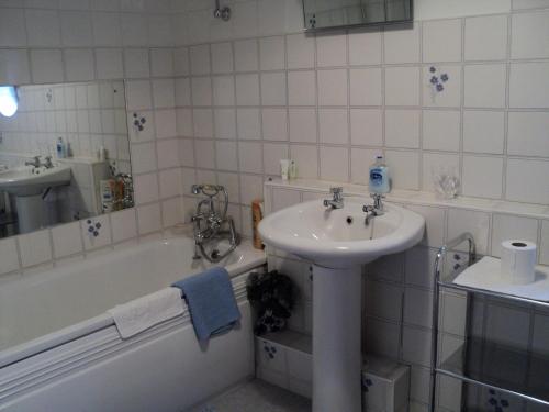W łazience znajduje się umywalka, wanna i umywalka. w obiekcie Maple Lodge w mieście Stockport